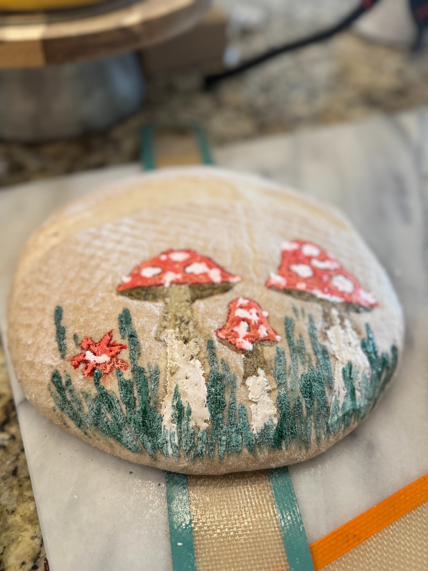 Stunning hand-decorated sourdough boule with painted mushroom and wildflower design